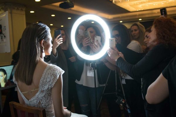 Make up artists taking photo of a bride during a seminar